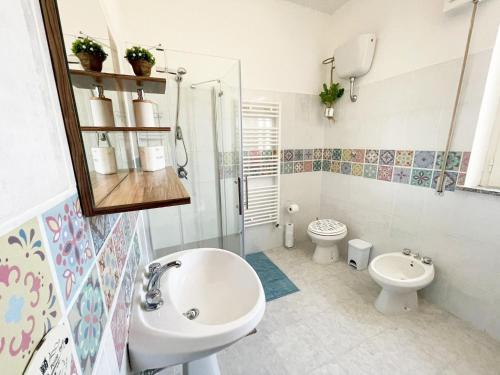 y baño con lavabo, aseo y ducha. en Casa Incantevole Vicino al Mare, en Baratili San Pietro