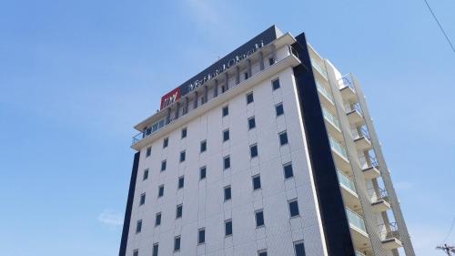 un edificio bianco con un cartello in cima di MyHotel Okazaki a Okazaki