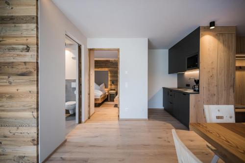 a kitchen and dining room with wood floors and a bedroom at Stöfflerhof in San Candido