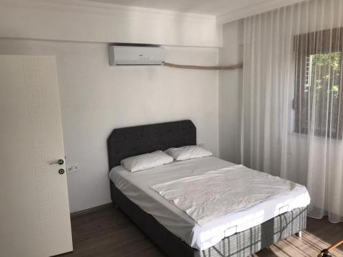 a bedroom with a bed in a room with a window at Kemer Guney Homes Apart in Kemer