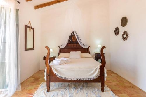 a bedroom with a bed with a canopy at Cas Catalá Sant Jordi in Sant Jordi