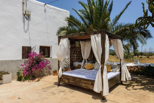 a canopy bed in front of a house at Cas Catalá Sant Jordi in Sant Jordi