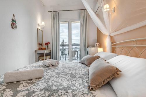 a bedroom with a bed with two pillows on it at Eros Beach Hotel in Benitses