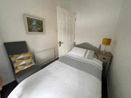 a small bedroom with a bed and a chair at Hill View House in Newry