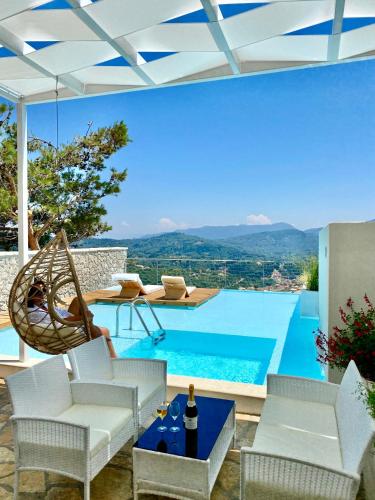 a villa with a swimming pool and a patio at Zeus Throne Suites in Afionas