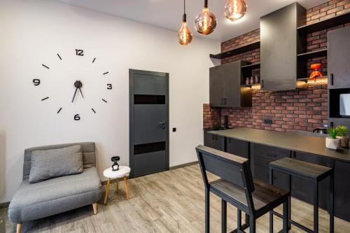 een keuken met een klok aan de muur en een stoel bij Stylish apartment in the center in Lviv