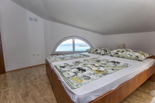 a bedroom with a large bed with a window at Ferienhaus Elena in Karlobag