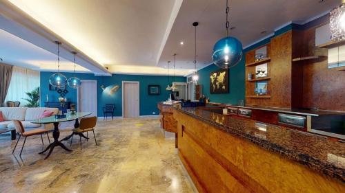 a living room with blue walls and a bar at Helios Beach Hotel in Milano Marittima