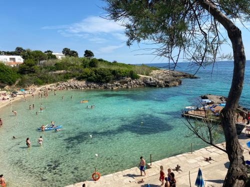 grupa ludzi w wodzie na plaży w obiekcie Villa Ninni w mieście Tarent