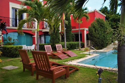 un grupo de sillas sentadas junto a una piscina en Los Altos Apartments & Studios en Managua