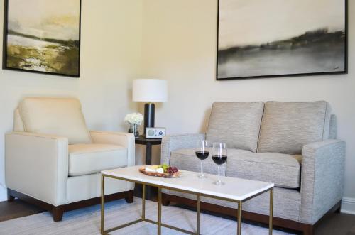 a living room with a couch and two glasses of wine at Milliken Creek Inn in Napa