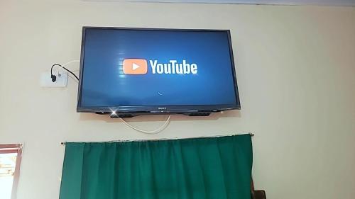 a tv on a wall with a youtube sign on it at Associação Sabesp Cardoso - SP in Cardoso