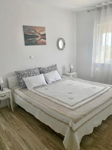 Un dormitorio blanco con una cama grande y una ventana en *New apartment* PETRA, en Hvar