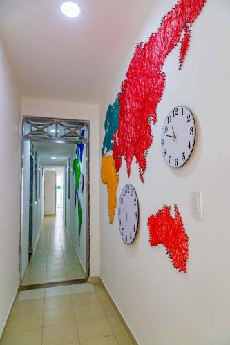 a room with clocks on the wall and a corridor at Luna Cartagena Airport Hotel in Cartagena de Indias