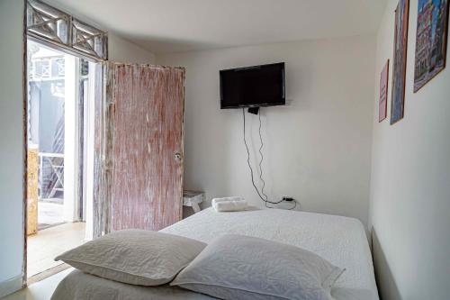 a bedroom with a bed and a television on the wall at Luna Cartagena Airport Hotel in Cartagena de Indias