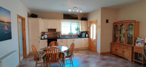 a kitchen with a table and chairs in a room at Ferry View Cottage in Belmullet