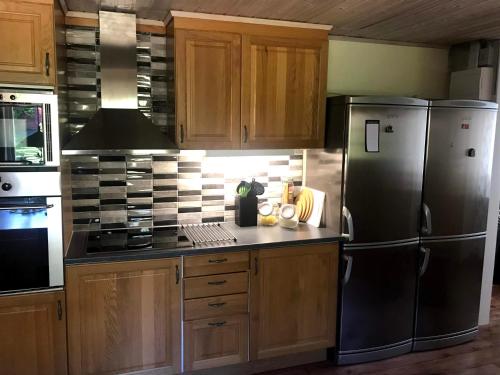 una cocina con electrodomésticos de acero inoxidable y armarios de madera en Holiday House in Oknö, Mönsterås, en Mönsterås