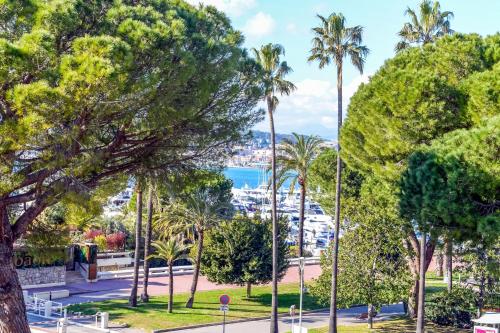un parc avec des palmiers et une vue sur l'océan dans l'établissement IMMOGROOm- two terraces - Sea view - CROISETTE - AC, à Cannes