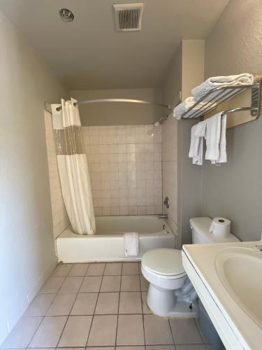 a bathroom with a tub and a toilet and a sink at Best Inn Motel Seaworld & Lackland AFB in San Antonio