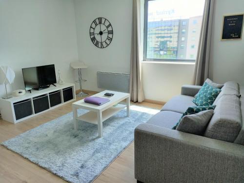 een woonkamer met een bank en een tafel bij Appartement ensoleillé au pied du Futuroscope in Chasseneuil-du-Poitou