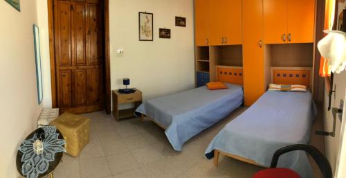 Dos camas en una habitación con naranja y azul en Maison di Leuca, en Leuca