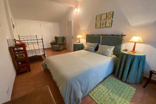 a bedroom with a large white bed and a chair at BLUE LAGOON - condomínio fechado LAGOA DE ÓBIDOS in Foz do Arelho