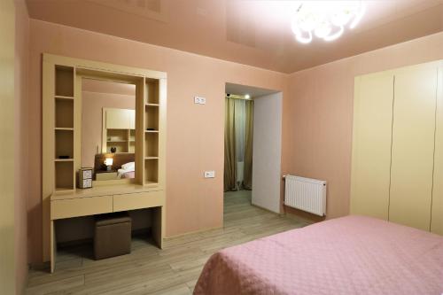 a bedroom with a bed and a vanity with a mirror at Apartment On Gudiashvili in Tbilisi City