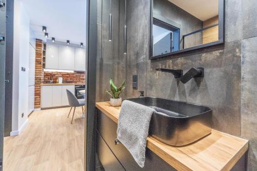 łazienka z czarną umywalką i kuchnią w obiekcie House Managers - Nadmotławie w Gdańsku