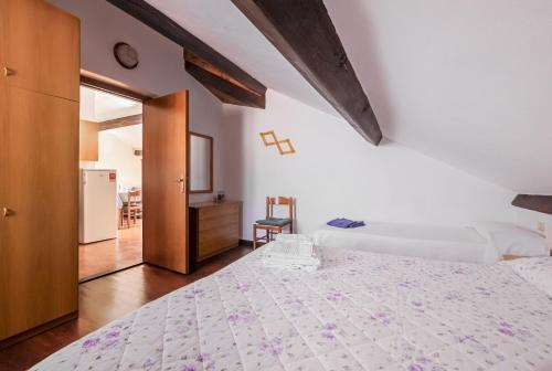 a bedroom with a white bed and a kitchen at Tino Brezza di Mare in Deiva Marina
