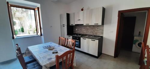 a kitchen with a table and a sink and a stove at Stefano apartment 2km Tropea boat cruise included in Parghelia