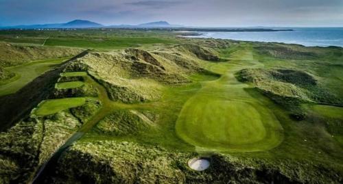 an aerial view of a golf course near the ocean at Ferry View Cottage in Belmullet