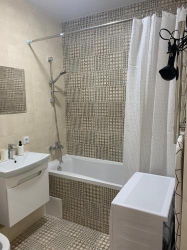 ein Bad mit einer Badewanne, einem Waschbecken und einer Dusche in der Unterkunft 0263-2 Смарт-апартаменты ЖК «Счастливый» in Kiew