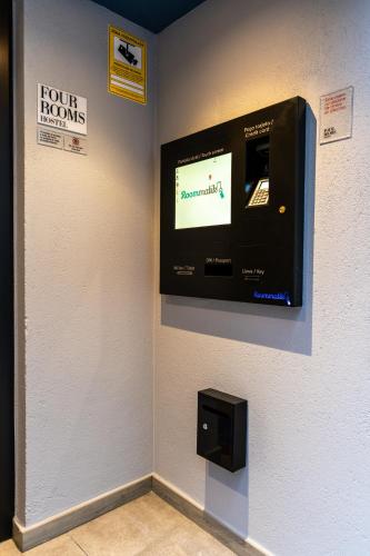 a television on a wall in a room at Four Rooms Hostel in Lugo