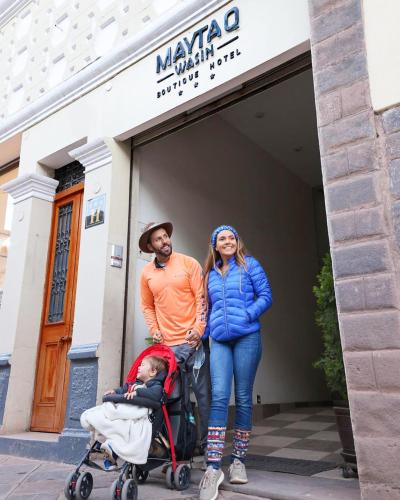 a man and a woman standing next to a baby in a stroller at Maytaq Wasin Boutique Hotel in Cusco