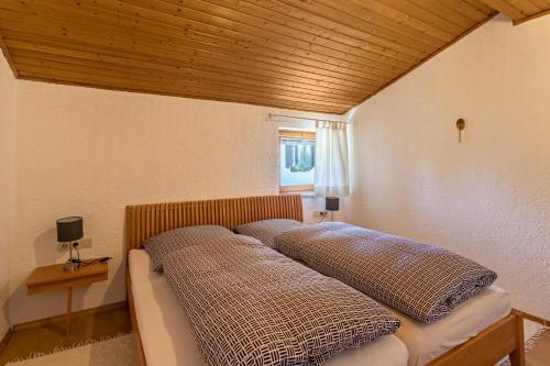 Bett in einem Zimmer mit zwei Kissen darauf in der Unterkunft Ferienwohnung Heinrich in Gmund am Tegernsee