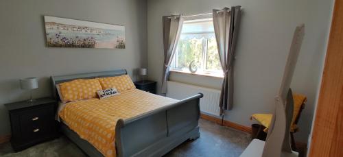 1 dormitorio con cama y ventana en Ferry View Cottage, en Belmullet