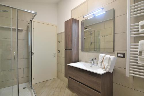 ein Bad mit einem Waschbecken, einer Dusche und einem Spiegel in der Unterkunft B&B Canavaccio in Urbino