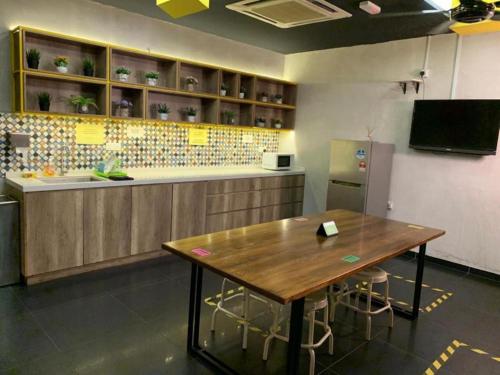 a kitchen with a wooden table and a counter at Smile Hotel Danau Kota in Kuala Lumpur