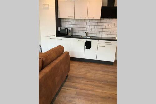 a living room with a couch and a kitchen at Sas van Gent, luxe appartement in centrum in Sas van Gent