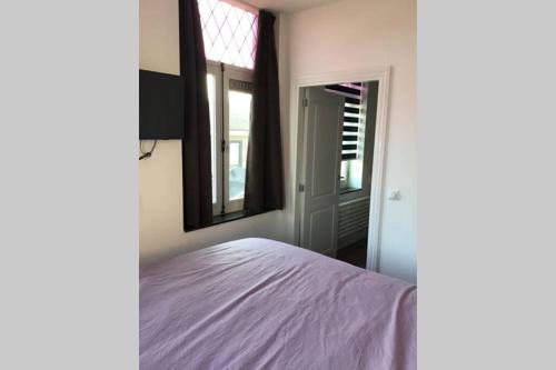 - une chambre avec un lit, une fenêtre et un miroir dans l'établissement Sas van Gent, luxe appartement in centrum, à Sas van Gent