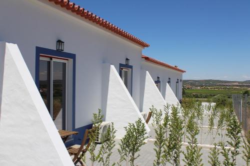 una fila de casas blancas con plantas delante de ellas en Quinta do Grande Lago, en Reguengos de Monsaraz