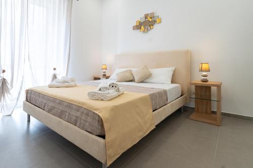 una camera da letto con un grande letto con due asciugamani di Lighthouse Apartment a Taormina