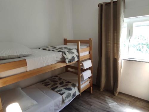 a bedroom with two bunk beds and a window at Apartment Bella Costa I in Kaštela