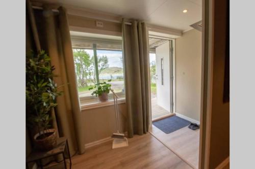 a hallway with a window and a floor fan at Smørfjord Ferieleilighet in Russenes