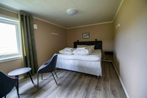 Schlafzimmer mit einem Bett, einem Tisch und Stühlen in der Unterkunft Smørfjord Ferieleilighet in Russenes