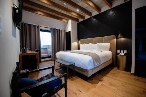 a bedroom with a large bed and a large window at Hotel Madi in San Miguel de Allende