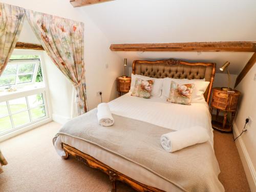 a bedroom with a large bed and a window at The Little Coach House in Brynkir