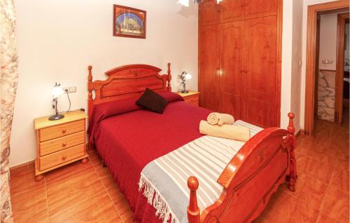 a bedroom with a red bed and a wooden dresser at 3 Bedroom Gorgeous Home In Montefrio in Montefrío