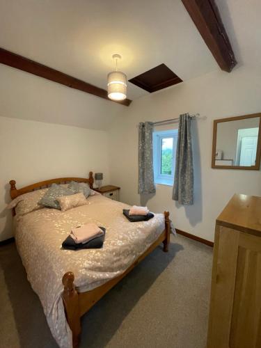 a bedroom with a bed with two towels on it at Cwt Mochyn in Corwen