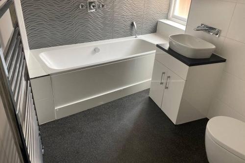 a bathroom with a tub and a sink and a toilet at Grade II listed, town house in Monmouth